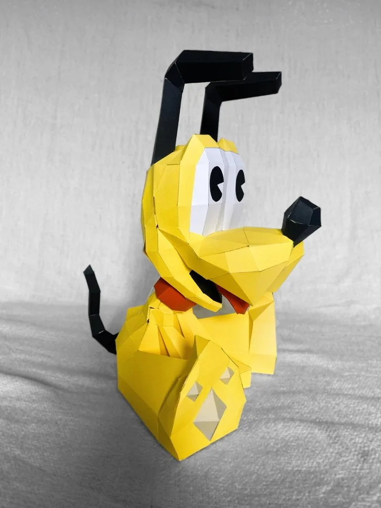 Pluto en papier vu de profil avec son collier rouge