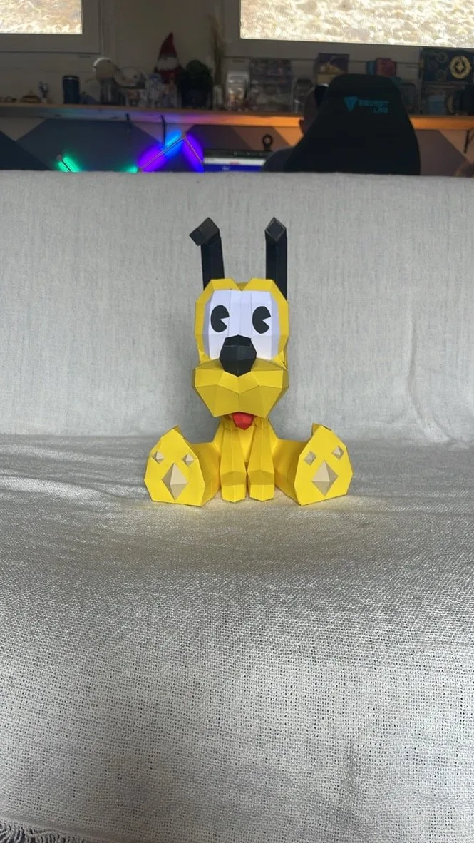 Chien Disney jaune assis sur un canapé langue sortie
