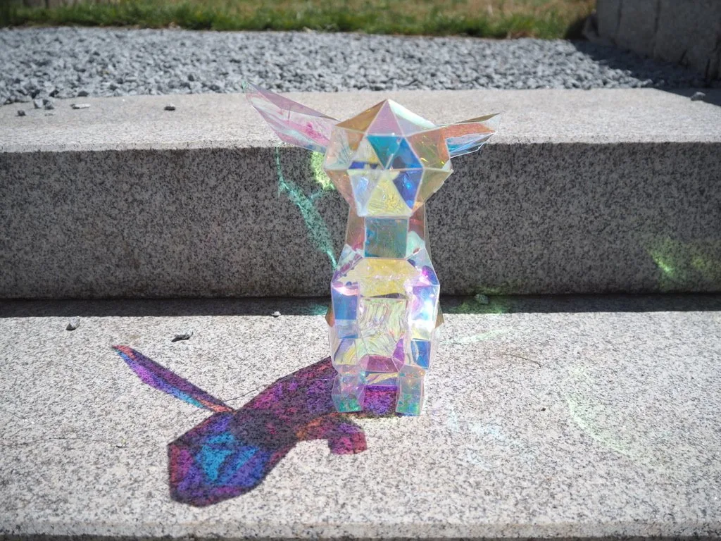 Pikachu assis en papier vu de dos sur escalier en granit