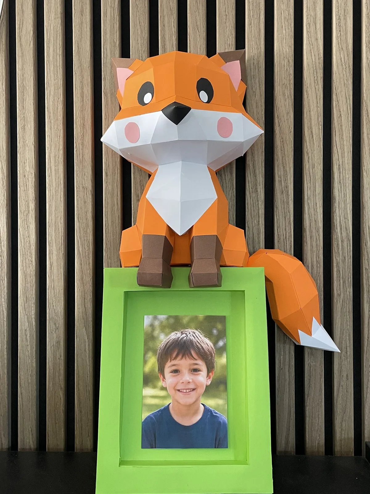 Renard orange assis sur étagère murale verte décorative