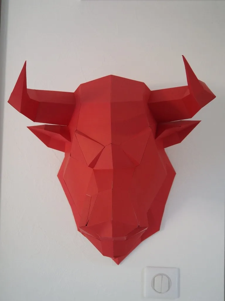 Tête de taureau rouge en papier fixée au mur