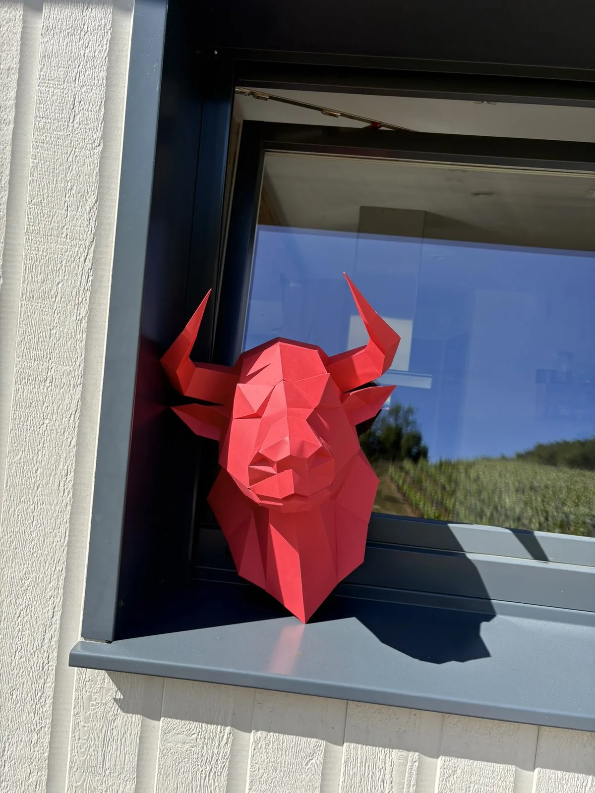 Tête de taureau en origami sur un rebord de fenêtre