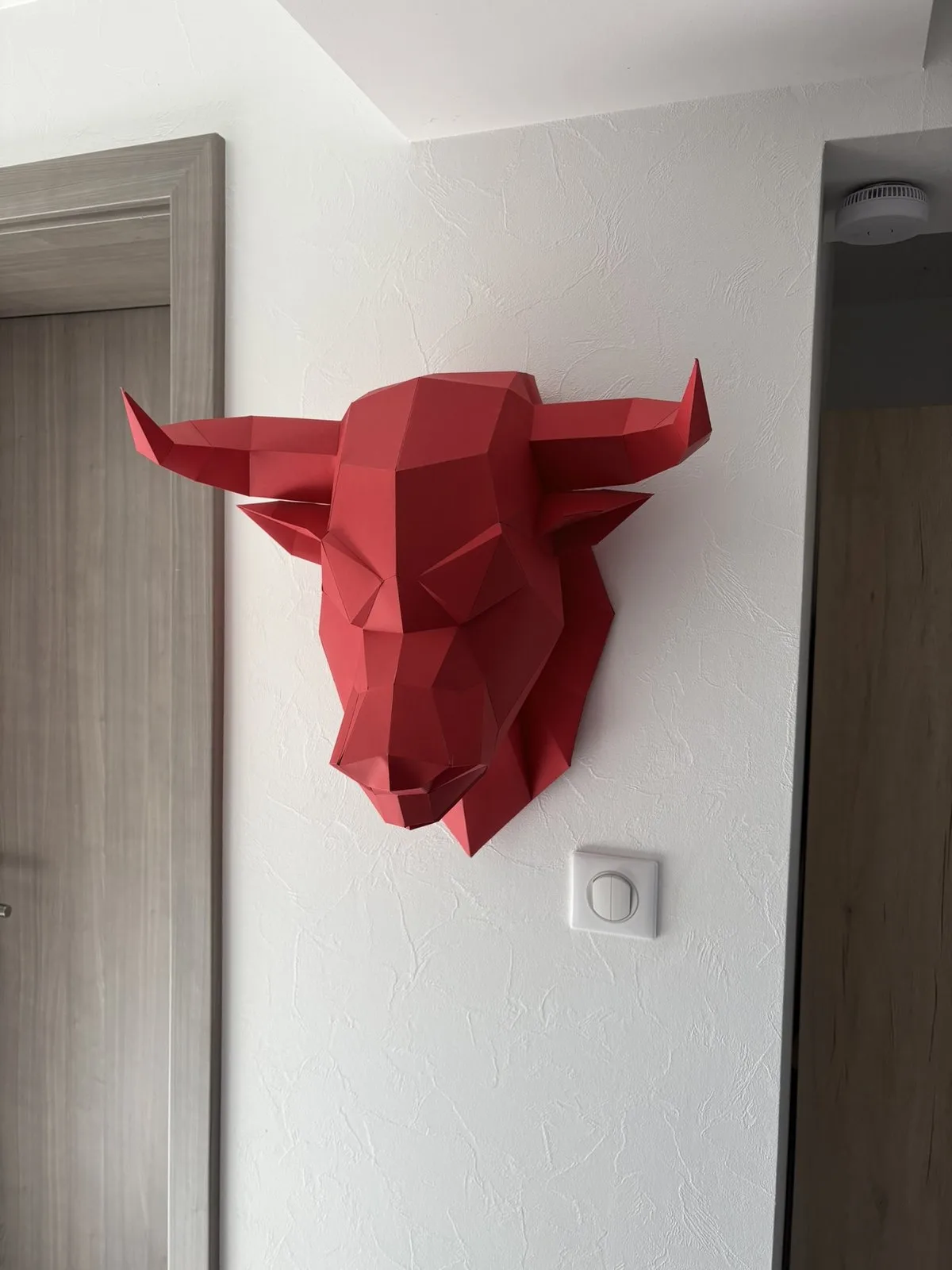 Taureau rouge en papier accroché près d’une porte