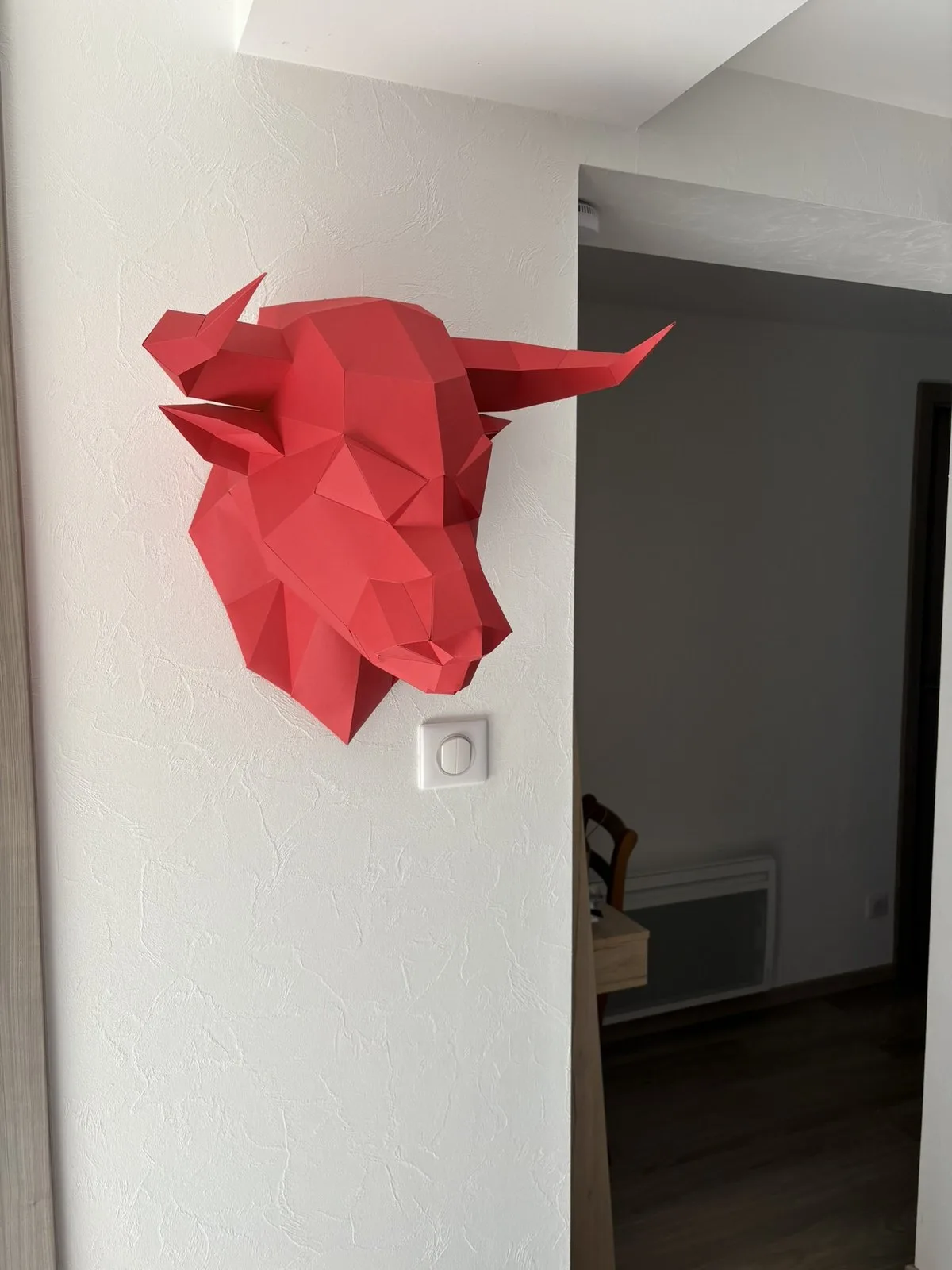 Décoration murale taurine rouge dans un couloir blanc