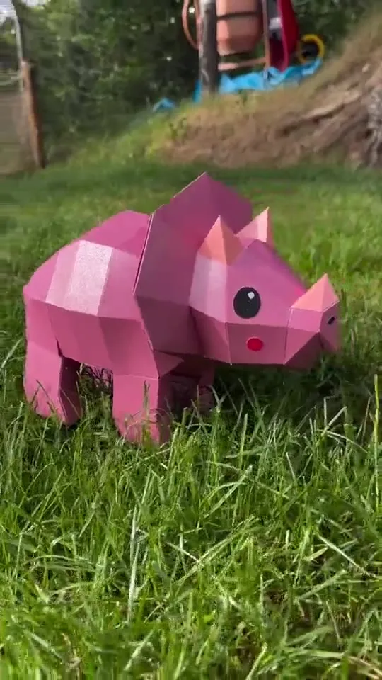 Petit tricératops rose aux joues rouges dans un pré