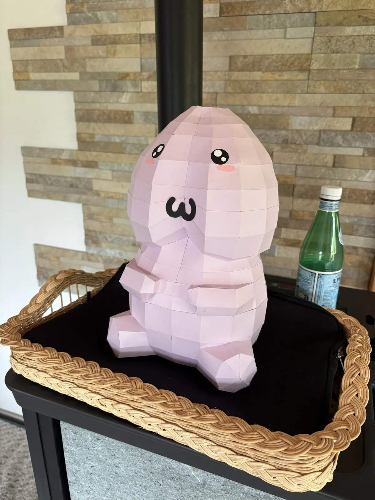 Pénis rose kawaii assis sur un plateau en rotin