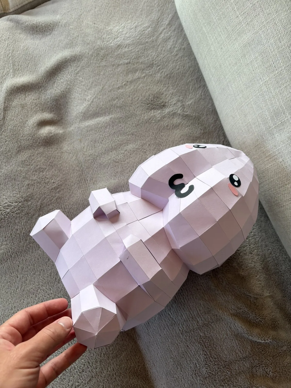Pénis en papier rose pâle allongé sur un canapé