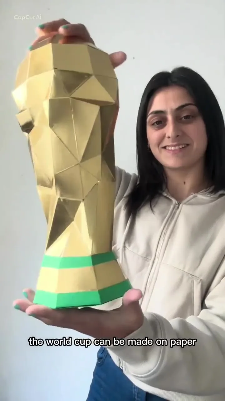 Trophée doré de la Coupe du Monde tenu par une personne
