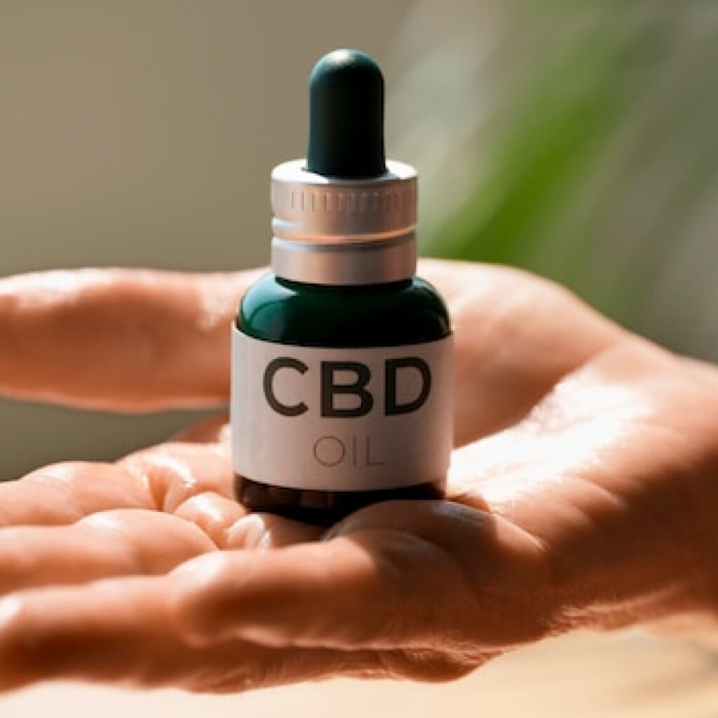 Flacon d’huile de CBD posé dans une main